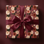 Luxury burgundy floral wrapping paper with cream roses and a satin bow, from Wrapped Studios.