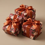Luxury floral wrapping paper with vintage rose pattern and copper bows on gift boxes by Wrapped Studios.
