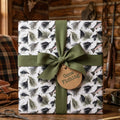 Fly fishing wrapping paper with trout, olive ribbon, and Gone Fishing tag by Wrapped Studios.