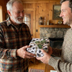 Men exchanging a gift in rustic fly fishing wrapping paper with twine and pine. By Wrapped Studios.