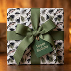 Fly fishing wrapping paper with trout pattern, green bow, and birthday tag by Wrapped Studios.
