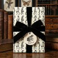 Gift wrapped in novelty frog print paper with a black velvet bow and "Hop to it!" tag.