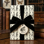 Gift wrapped in novelty frog print paper with a black velvet bow and "Hop to it!" tag.