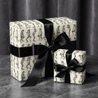 Two gift boxes wrapped in funny frog print paper with elegant black satin bows.