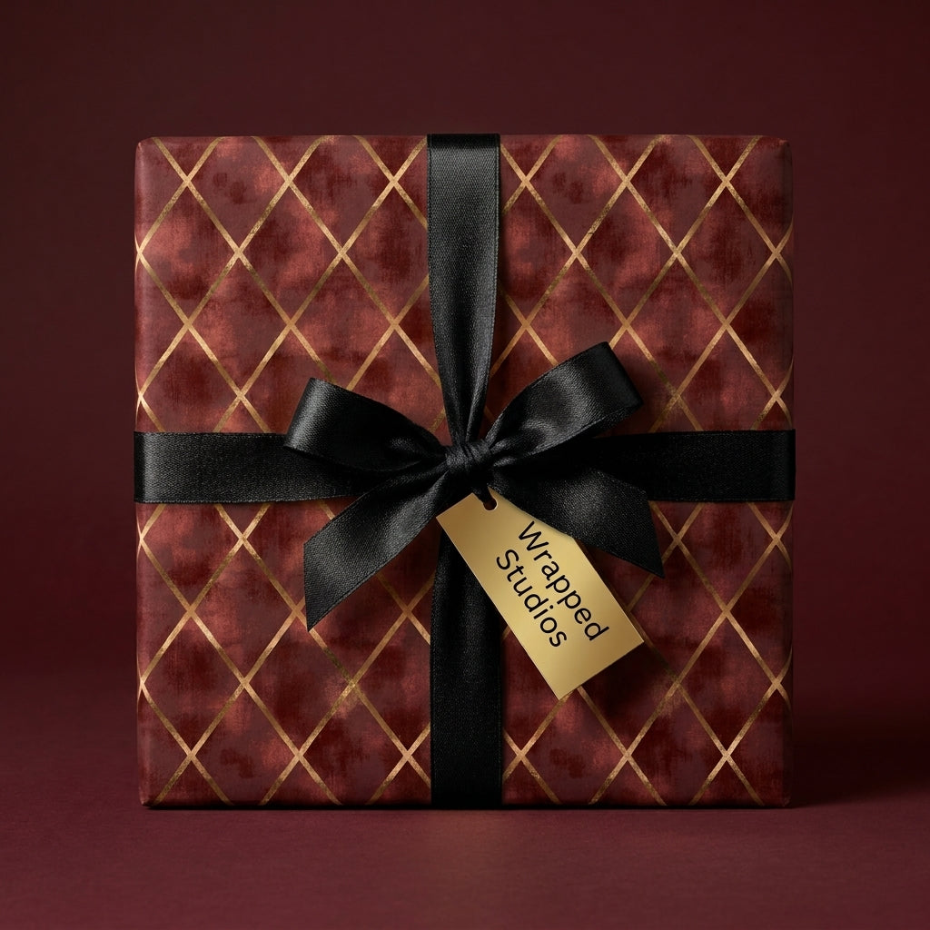 Luxury burgundy wrapping paper with gold diamond pattern and black satin bow by Wrapped Studios.
