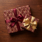 Luxury burgundy and gold wrapping paper on gift boxes with satin bows, by Wrapped Studios.