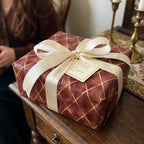 Luxury burgundy and gold Christmas gift wrap with cream bow and "With Love" tag, by Wrapped Studios.