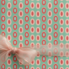Mint green and pink modern polka dot wrapping paper with a sheer peach ribbon bow, perfect for a chic birthday gift.