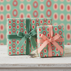 Retro patterned gift wrap in teal, red, and pink with velvet ribbons, perfect for vintage-style birthday or holiday presents.