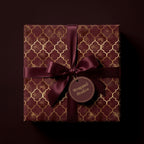 Luxury burgundy and gold geometric wrapping paper with a satin ribbon by Wrapped Studios.