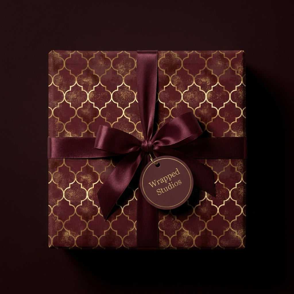 Luxury burgundy and gold geometric wrapping paper with a satin ribbon by Wrapped Studios.