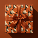 Spooky ghost Halloween wrapping paper with a copper satin ribbon on a gift box by Wrapped Studios.