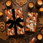Cute ghost Halloween wrapping paper on orange gift boxes with a black ribbon by Wrapped Studios.