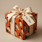 Cute ghost Halloween wrapping paper by Wrapped Studios on a gift box with a cream bow.