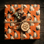 Spooky ghost Halloween wrapping paper by Wrapped Studios, tied with rustic twine and pinecones.