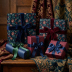Luxury vintage floral wrapping paper on Christmas gift boxes with velvet bows by Wrapped Studios.