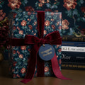 Luxury dark floral wrapping paper with burgundy velvet ribbon and tag by Wrapped Studios.