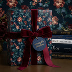 Luxury dark floral wrapping paper with burgundy velvet ribbon and tag by Wrapped Studios.