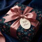 Luxury floral wrapping paper with dusty rose satin bow and "With Love" tag by Wrapped Studios.