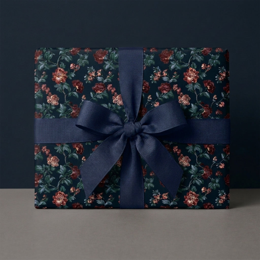 Elegant dark floral wrapping paper with a navy blue ribbon bow by Wrapped Studios.