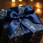 Luxury vintage floral wrapping paper with a navy satin bow and tag, by Wrapped Studios.