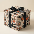 Spooky vintage Halloween wrapping paper with pumpkins and a black satin bow, from Wrapped Studios.