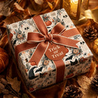 Halloween wrapping paper with vintage ghost and pumpkin pattern, orange bow, and tag by Wrapped Studios.