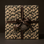 Vintage graduation gift wrap with a black and white graduate pattern and brown ribbon bow by Wrapped Studios.