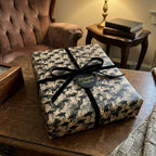 Vintage graduation wrapping paper with black velvet ribbon on a gift box by Wrapped Studios.