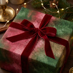 Elegant green and red watercolor Christmas wrapping paper with a velvet bow by Wrapped Studios.