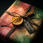 Rustic green and red Christmas wrapping paper with dried orange and twine by Wrapped Studios.