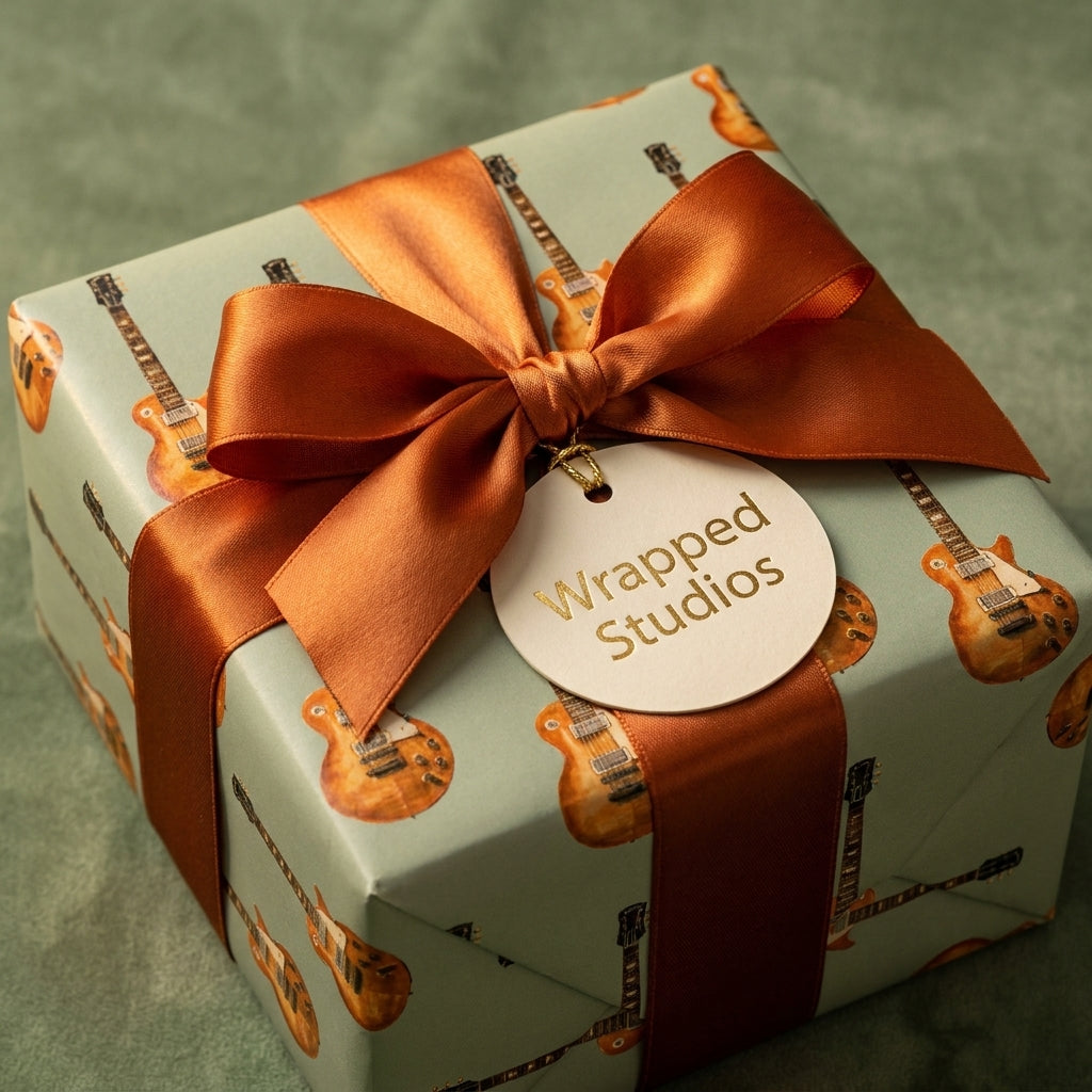 Vintage electric guitar wrapping paper on a gift box with copper ribbon and a Wrapped Studios tag.