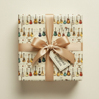 Gift box wrapped in beige guitar-themed wrapping paper with a satin gold ribbon.