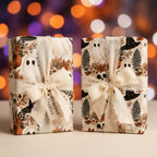 Vintage Halloween wrapping paper featuring cute ghosts and autumn florals with cream bows by Wrapped Studios.