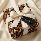 Spooky Halloween wrapping paper with pumpkins and ghosts, tied with a cream ribbon by Wrapped Studios.