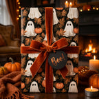 Ghost and pumpkin Halloween wrapping paper with an orange velvet bow by Wrapped Studios.