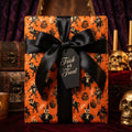 Vintage Halloween wrapping paper with a black satin bow and Trick or Treat tag by Wrapped Studios.