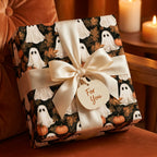 Elegant ghost and pumpkin Halloween wrapping paper with cream satin bow by Wrapped Studios.
