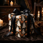 Spooky ghost wrapping paper with pumpkins and a black satin bow on a gift box, by Wrapped Studios.