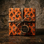 Vintage Halloween wrapping paper with spooky orange monsters and a rustic twine bow by Wrapped Studios.