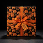 Spooky Halloween gift wrap with jack-o'-lantern pattern and orange ribbon bow, by Wrapped Studios.