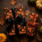 Spooky jack-o-lantern Halloween wrapping paper with satin and velvet bows on wood by Wrapped Studios.