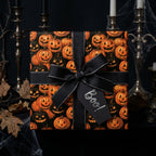 Halloween pumpkin wrapping paper with a black ribbon bow and "Boo!" tag by Wrapped Studios.