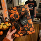 Spooky jack-o'-lantern Halloween wrapping paper with a black bow by Wrapped Studios.