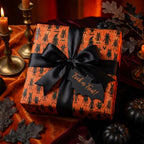 Spooky orange Halloween wrapping paper by Wrapped Studios with black monster pattern and elegant satin bow.