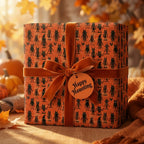 Spooky orange Halloween wrapping paper with black monsters and a velvet bow, by Wrapped Studios.