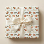 Vintage floral wrapping paper with roses, butterflies, and a cream satin bow. Luxury gift wrap by Wrapped Studios.