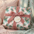 Vintage botanical Christmas wrapping paper with a pink velvet bow and Noel tag by Wrapped Studios.