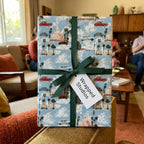 Vintage travel wrapping paper with retro cars, palm trees, and green ribbon, by Wrapped Studios.