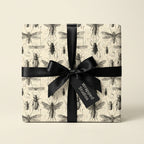 Gift wrapped in insect print wrapping paper with black satin ribbon and bow.